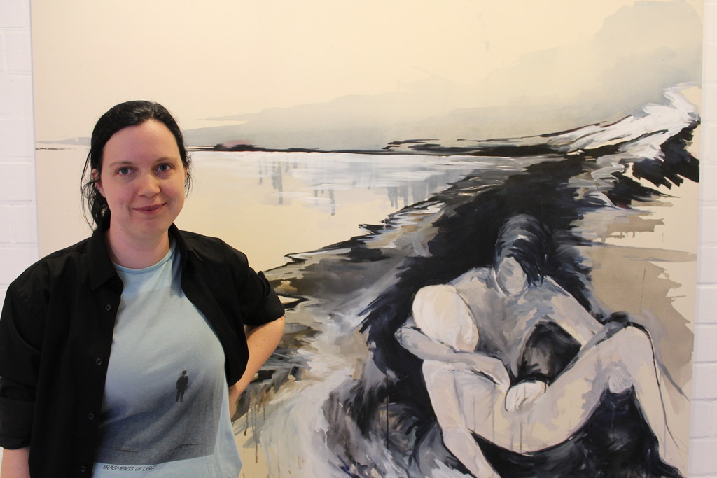 Das Bild zeigt die Künstlerin Ute Schätzmüller vor ihrem Gemälde 'the guardian'
