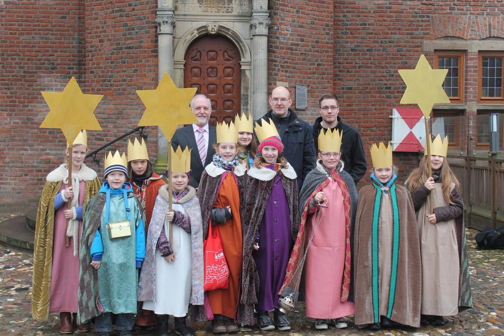 Das Bild zeigt Kinder im Sternsänger Kostümen vor den Rathaus