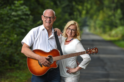 Duo HörBar Foto des Duo HörBar, Astrid und Andre Philippi mit Gitarre auf einem Weg im Grünen