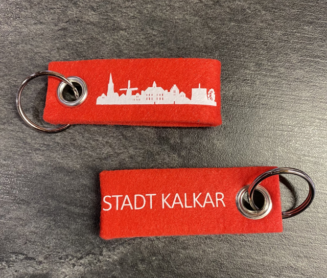 Das Foto zeigt die Vorder- und Rückseite der Kalkarer Schlüsselanhänger.