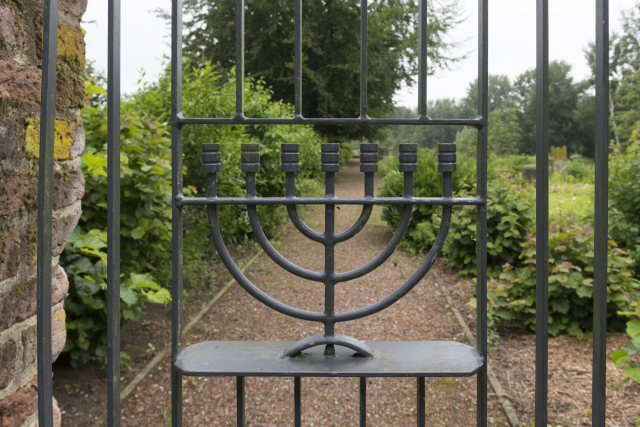 Das Foto zeigt eine Abbildung der Menora im Eingangstor zum jüdischen Friedhof in Kalkar.
