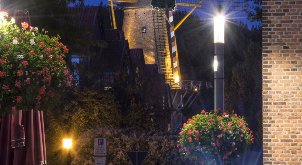 Blick vom Marktplatz auf die Kalkarer Stadtwindmühle in der Dämmerung mit Beleuchtung
