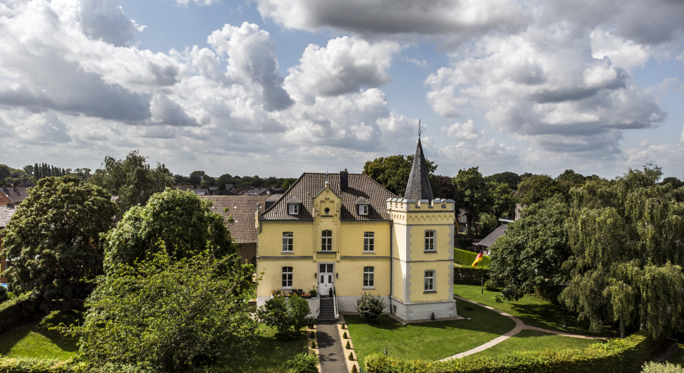 Blick aus der Vogelperspektive aus Haus Grieth mit umgebenden Grünflächen und Baumbestand