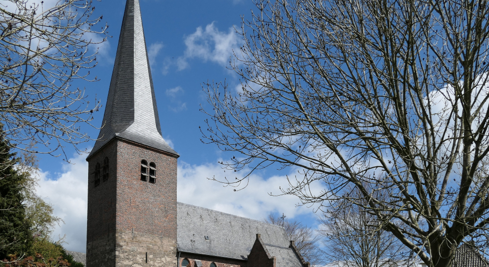 St. Antonius Kirche Hanselaer, Außenaufnahme von der Längsseite des Gebäudes über den Friedhof hinweg