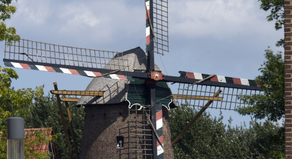 Blicke auf den Turm aus Backstein und die Flügel der Kalkarer Mühle