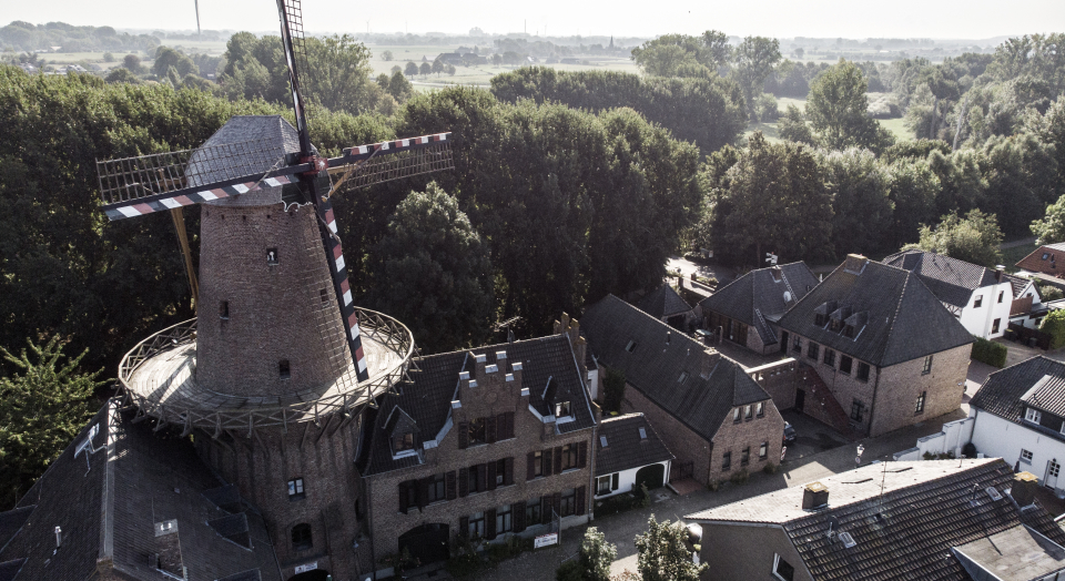 Blicke aus der Vogelperspektive auf die Kalkarer Mühle und angrenzende Gebäude und Bäume
