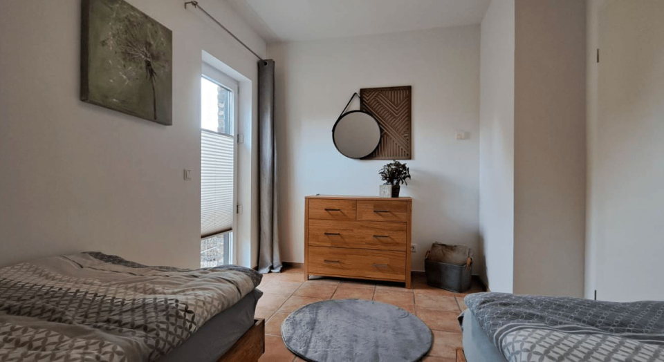 Ferienhaus Maas, kleines Schlafzimmer mit Doppelbett, Einzelbett und Kommode