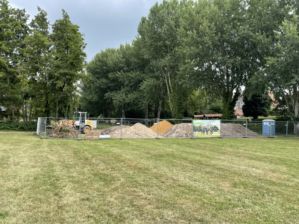 Bautätigkeit zur Umgestaltung des Horster Grabens Baustelle mit Bauzaun und Baufahrzeug, eingerichtet zur Umgestaltung der Wall- und Grabenzone in Kalkar, Wiese im Vordergrund, Bäume im Hintergrund