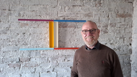 Foto des Künstlers Klaus Ebbers vor einem seiner Kunstwerke bei der Ausstellung in Haus Haan in Grieth am Rhein
