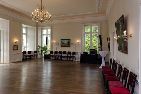 Festsaal der Burg Boetzelaer, vorbereitet für eine Tanzveranstaltung mit Parkettboden und Stuhlreihen an den Wänden
